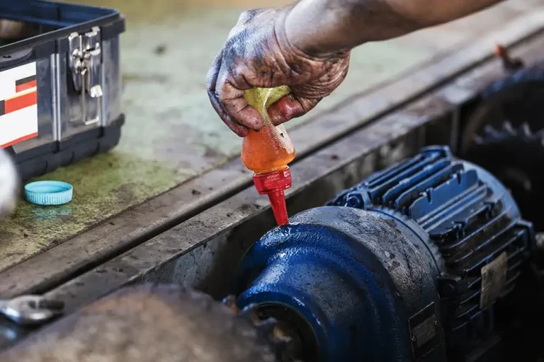 close-up-hand-pouring-oil-from-bottle-machine