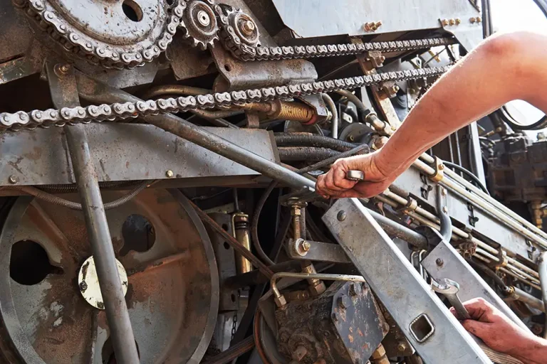 combine-machine-service-mechanic-repairing-motor-outdoors